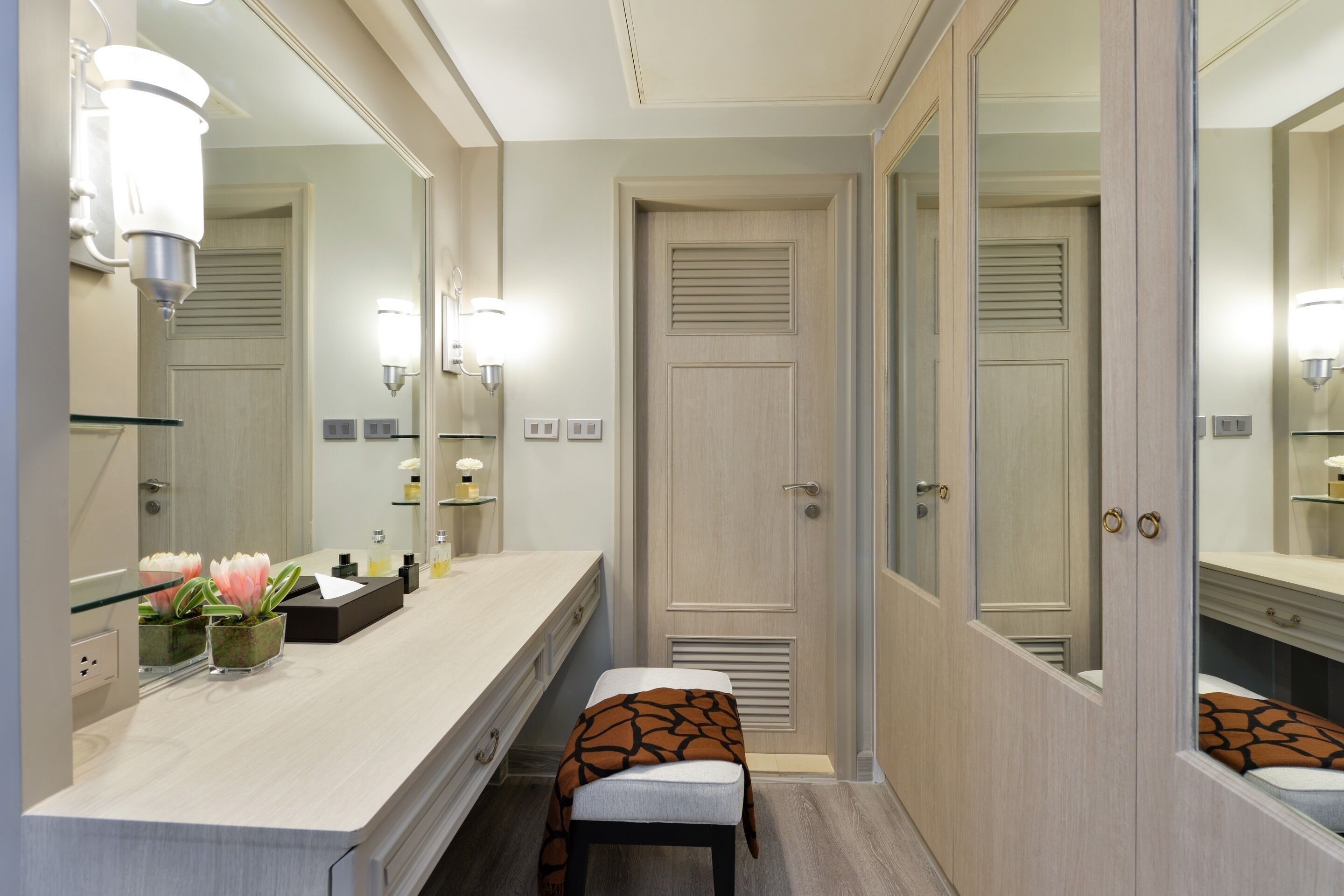 Un baño moderno con tocador, espejo y armario.