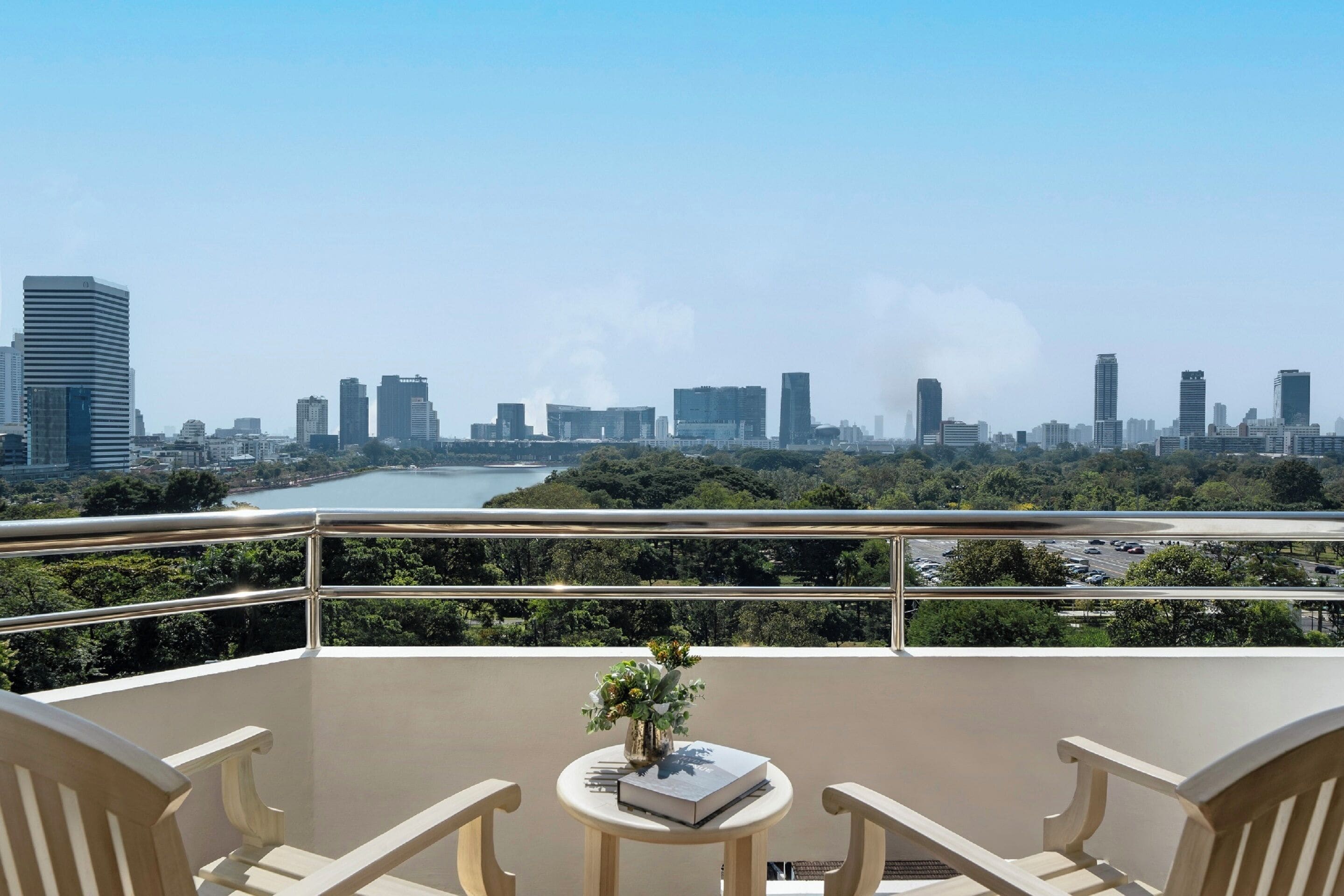 A balcony with a view of a city skyline and a river.