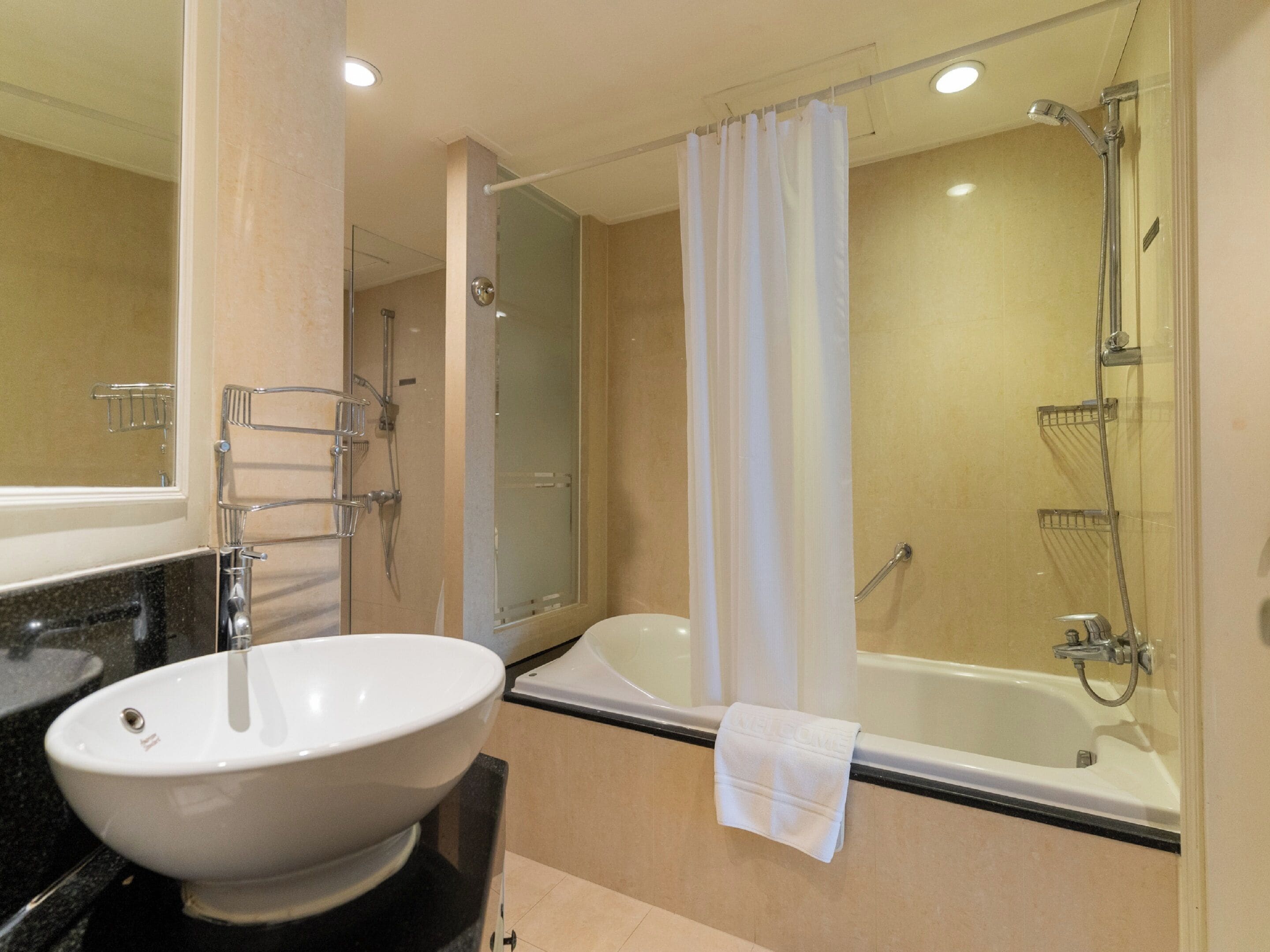 A modern bathroom with a large white sink, a bathtub, and a shower.