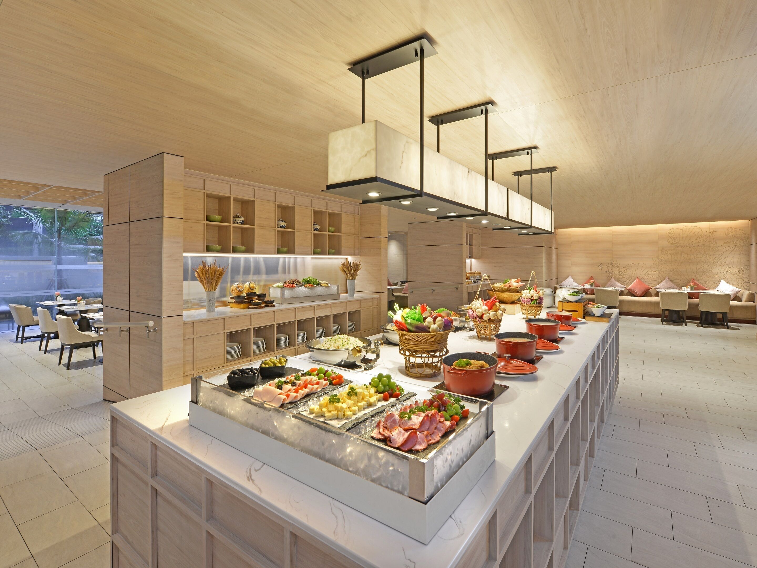 A buffet setup with various food items and a seating area with tables and chairs.