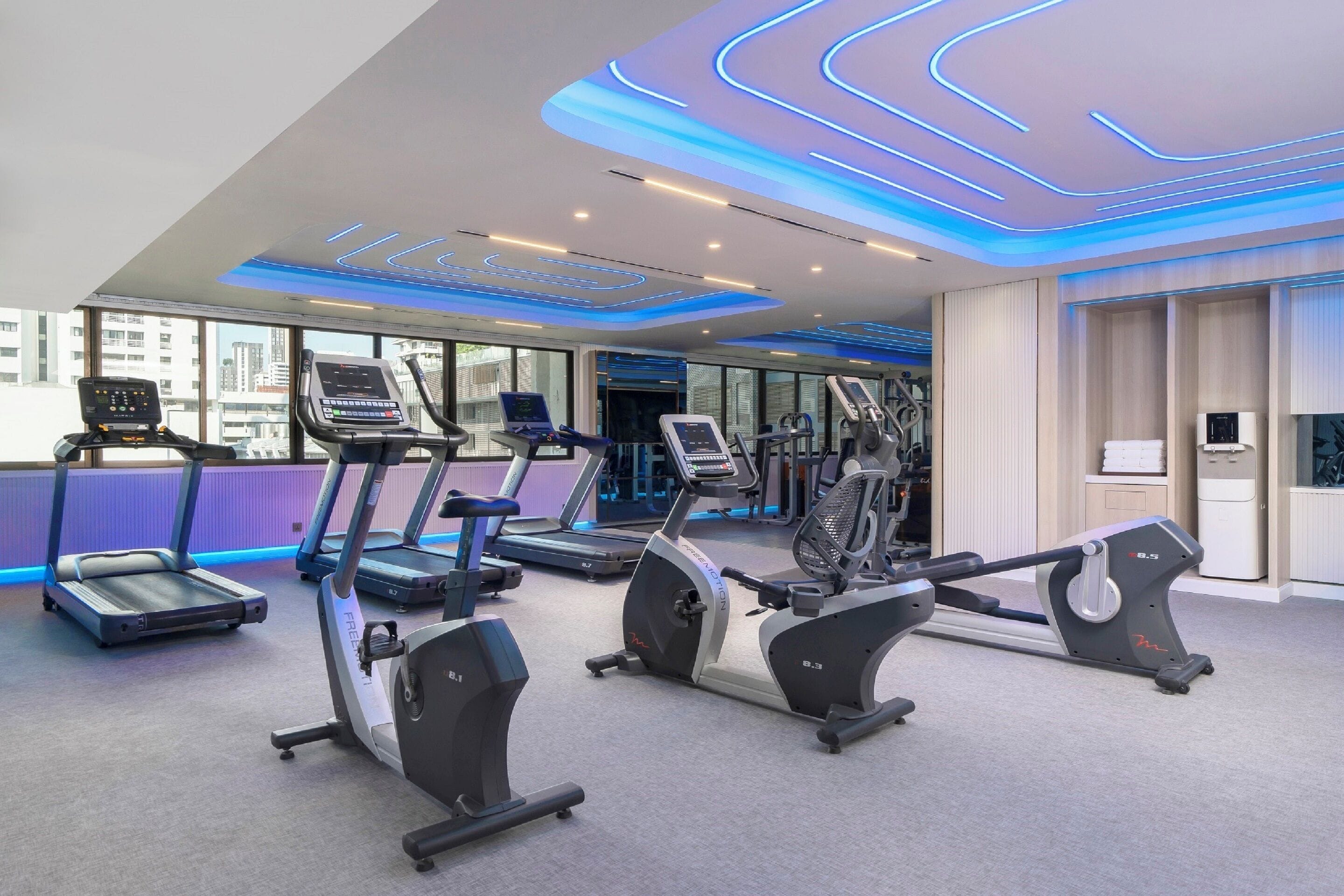 Ein modernes Fitnessstudio mit Laufbändern, Crosstrainern und Rudergeräten.