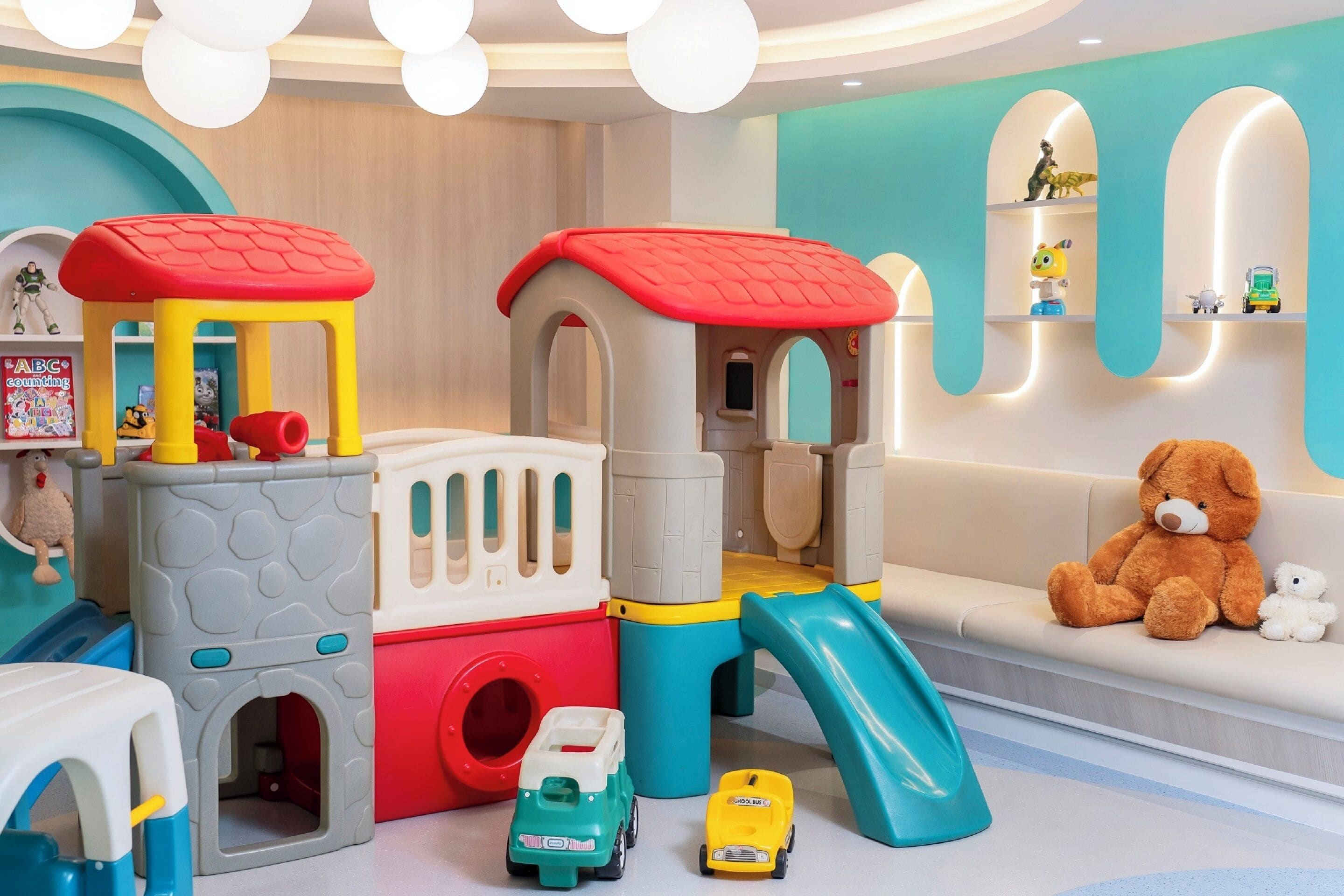 A children's play area with a slide, climbing structures, and toy vehicles.