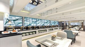 A modern restaurant with a long counter, multiple seating areas, and a decorative ceiling. - Centre Point Plus Hotel Pratunam (Bangkok)