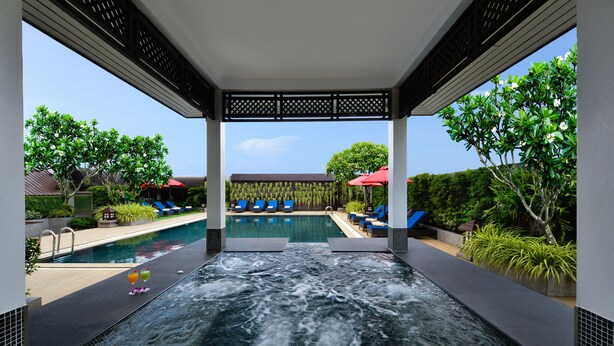 A spa area with a hot tub, lounge chairs, and a pool. - Centre Point Plus Hotel Pratunam (Bangkok)