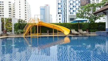 Relax by the pool surrounded by lush greenery and comfortable seating.