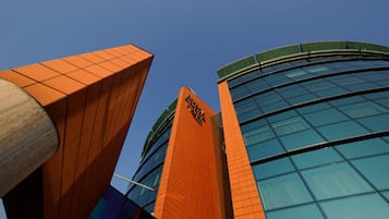 A modern building with a prominent orange facade and a glass structure.