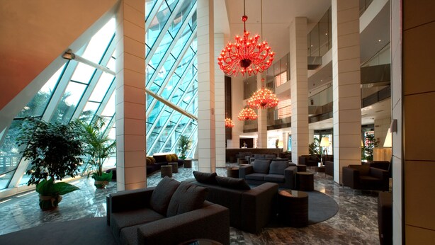 A spacious lobby with modern furnishings, large windows, and decorative lighting. - Antony Palace Hotel (Marcon)