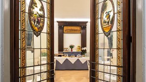 A reception area with a reception desk, framed artwork, and a view of the dining area.