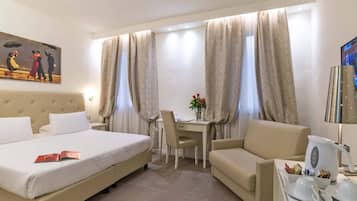 Habitación de hotel con cama, escritorio, silla, sofá, cafetera y televisor.