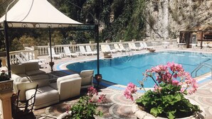 Una piscina al aire libre, sombrillas, tumbonas