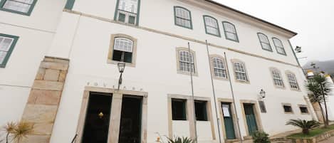 A white building with multiple windows and a sign that reads "POVOSA".