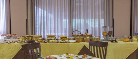 A breakfast buffet with various food items and beverages on a table.