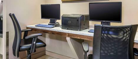 Un espacio de trabajo con dos monitores, una impresora y dos sillas.