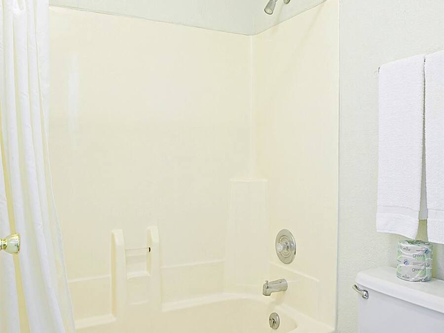 Un baño con bañera, inodoro y cortina de ducha.