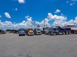 Un estacionamiento con varios camiones aparcados.