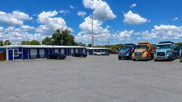 A motel with a row of parked trucks and cars in front.