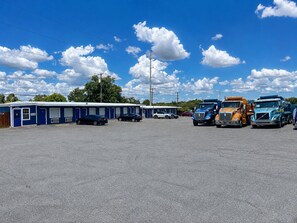 A motel with a row of parked trucks and cars in front.