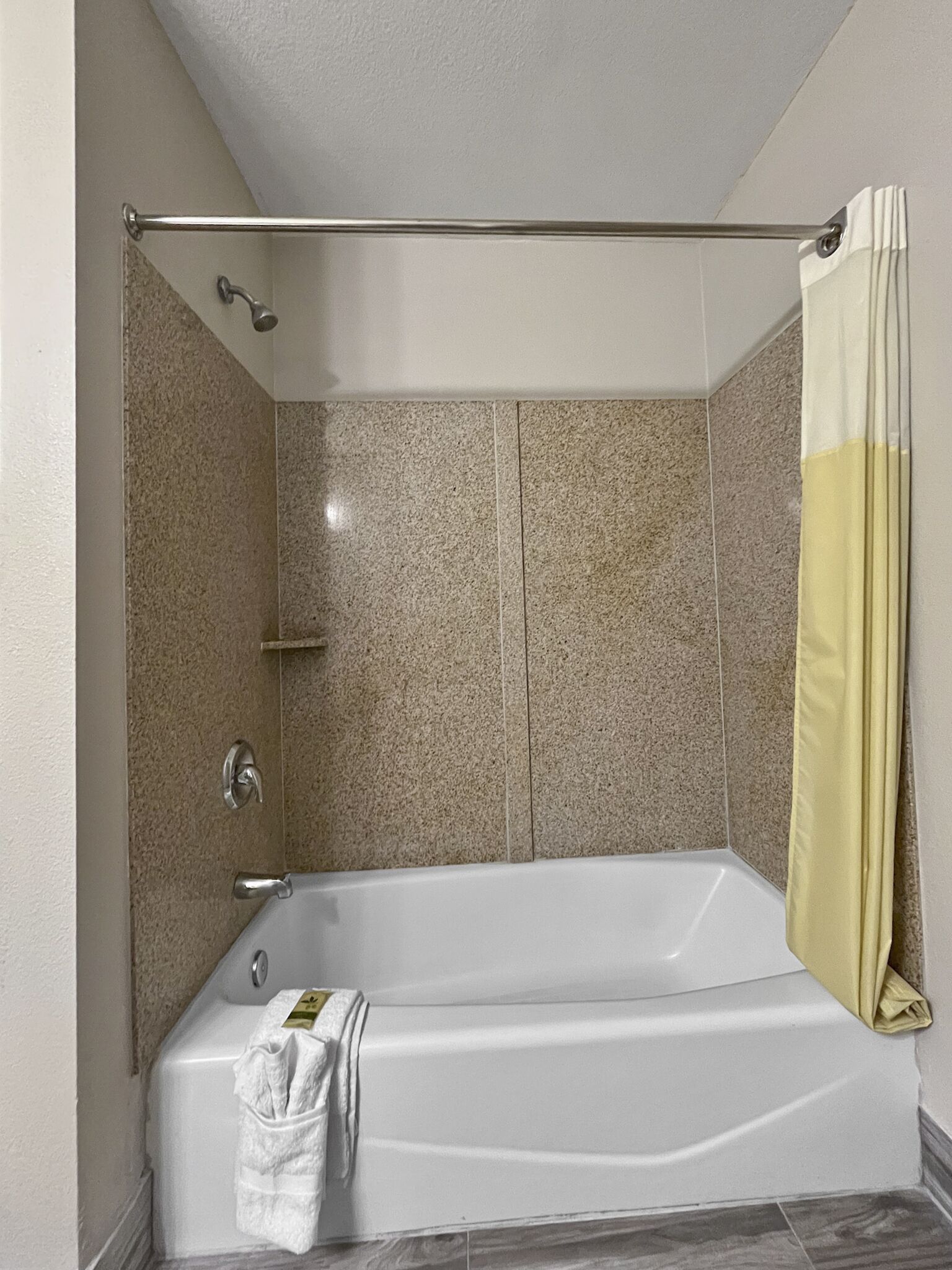 Un baño moderno con una bañera independiente, una cortina de ducha y un perchero para toallas.