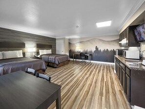 A hotel room with two beds, a desk, a chair, a television, and a microwave. - Rodeo Lodge (Clovis)