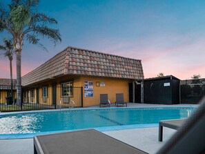 Una piscina al aire libre, sombrillas, tumbonas