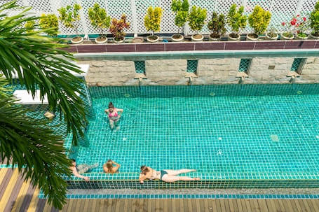 Una piscina al aire libre, sombrillas, sillones reclinables de piscina
