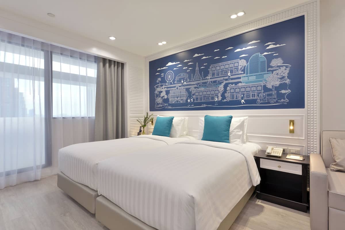 Een moderne hotelkamer met een groot bed, een nachtkastje met een telefoon en een stadsgezicht op de muur.