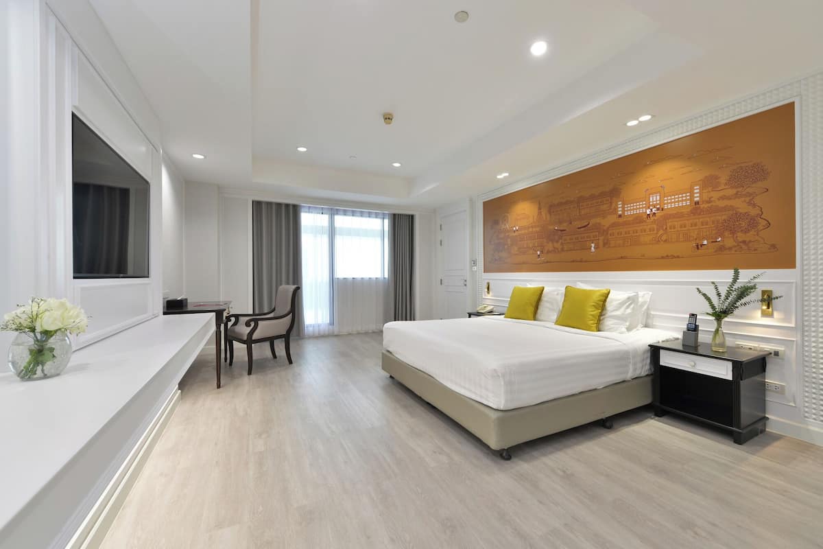 Een moderne hotelkamer met een groot bed, een bureau en een stoel.