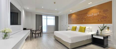Una habitación de hotel moderna con una cama grande, un escritorio y una silla.