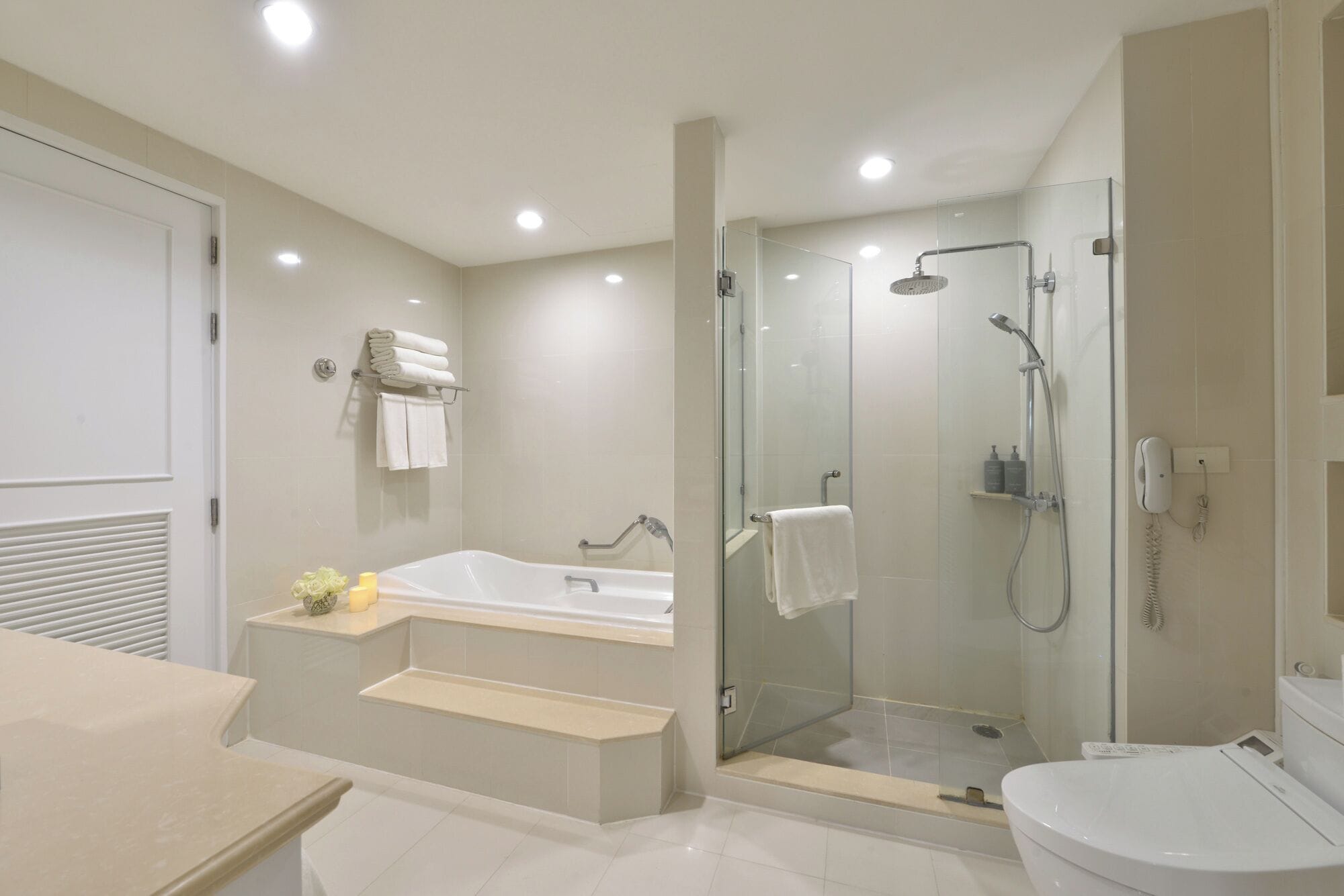 A modern bathroom with a glass-enclosed shower, a freestanding bathtub, and a toilet.