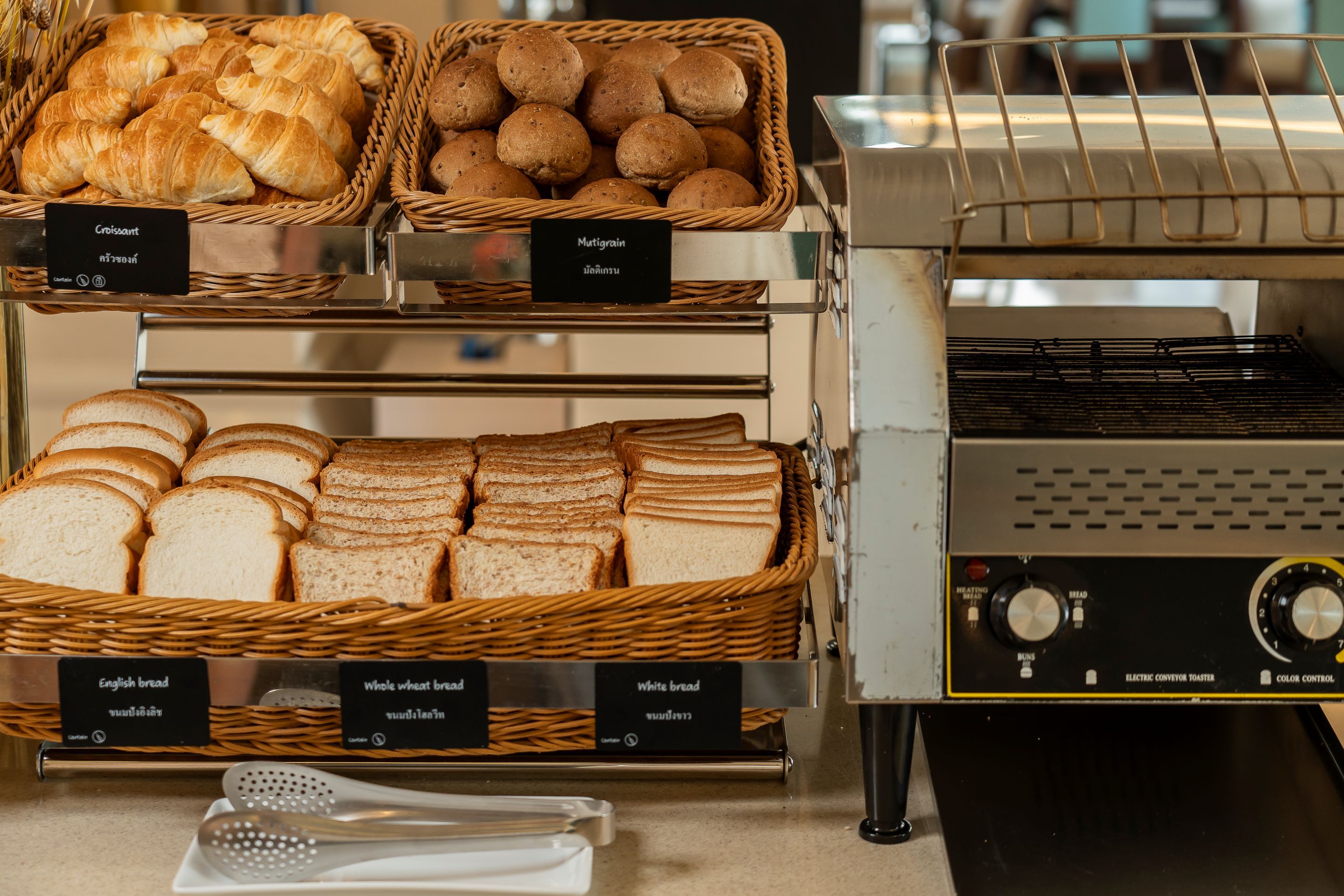Un mostrador de panadería con diferentes tipos de pan y una máquina para hacer pan.