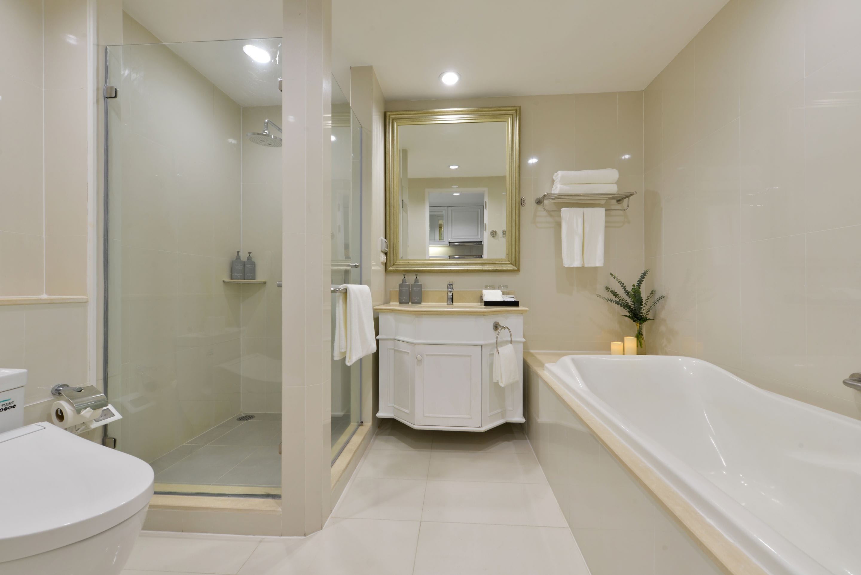 A modern bathroom with a glass-enclosed shower, a freestanding bathtub, and a vanity with a mirror.