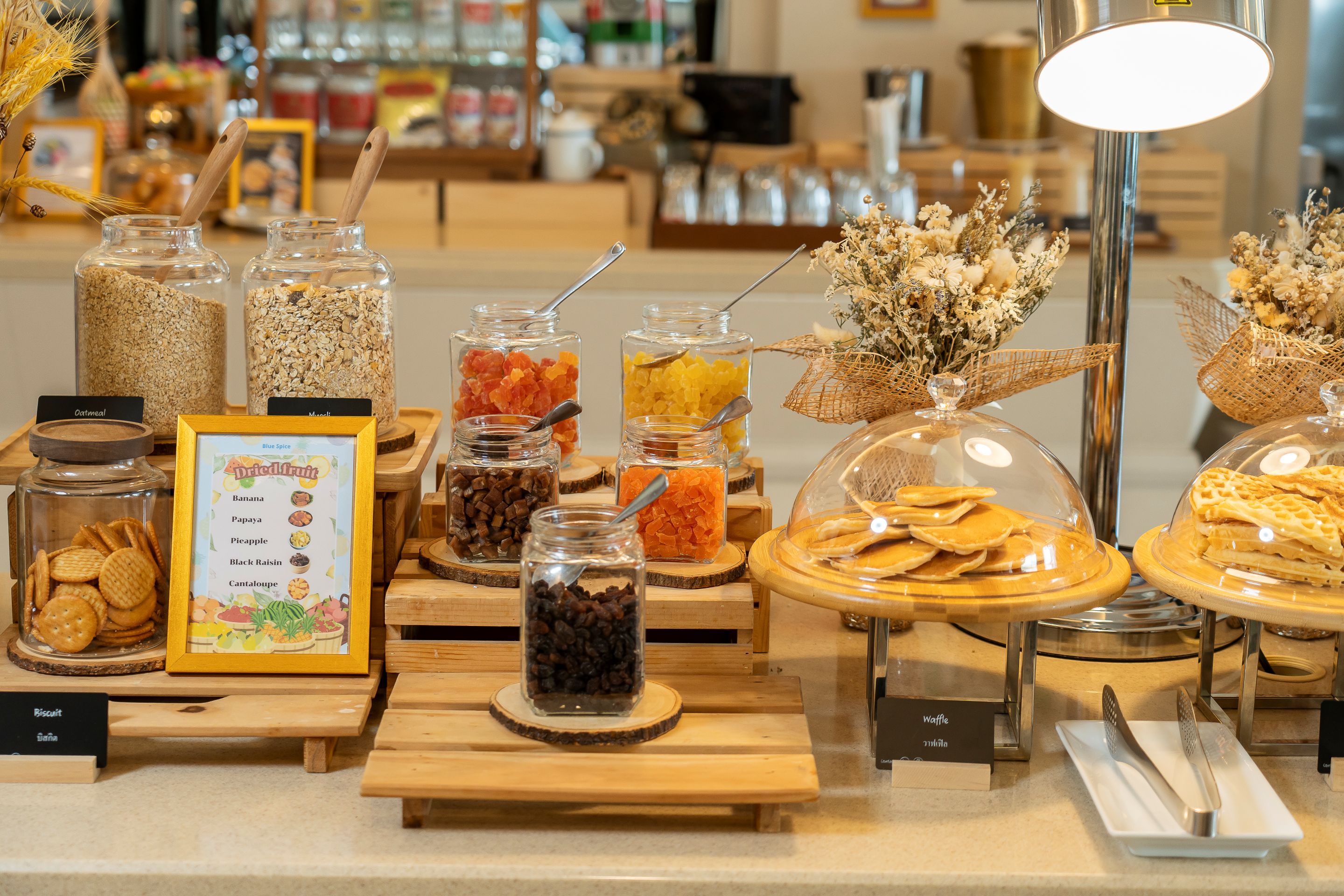 A breakfast buffet with various food items and a sign indicating the types of dried fruit available.