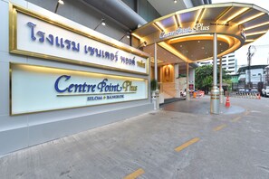 The entrance to Centre Point Plus in Silom, Bangkok, featuring a prominent sign and a covered entrance area.