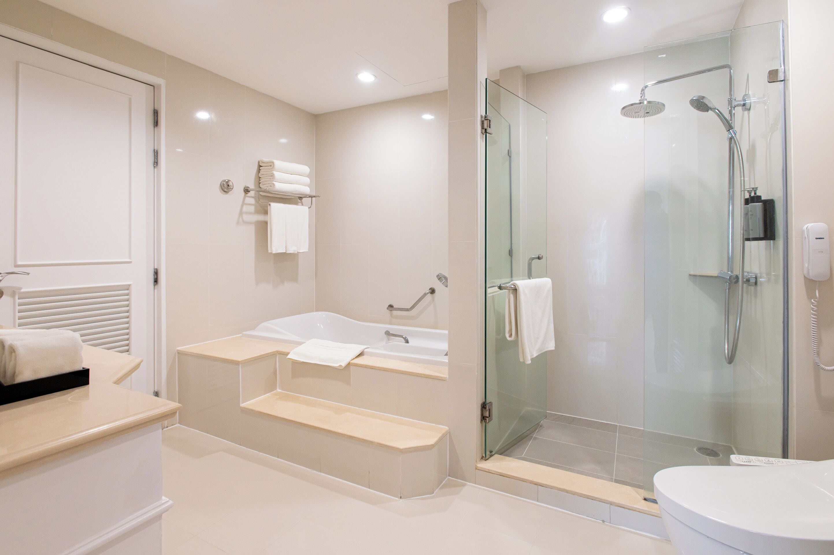 A modern bathroom with a glass-enclosed shower, a double sink vanity, and a toilet.
