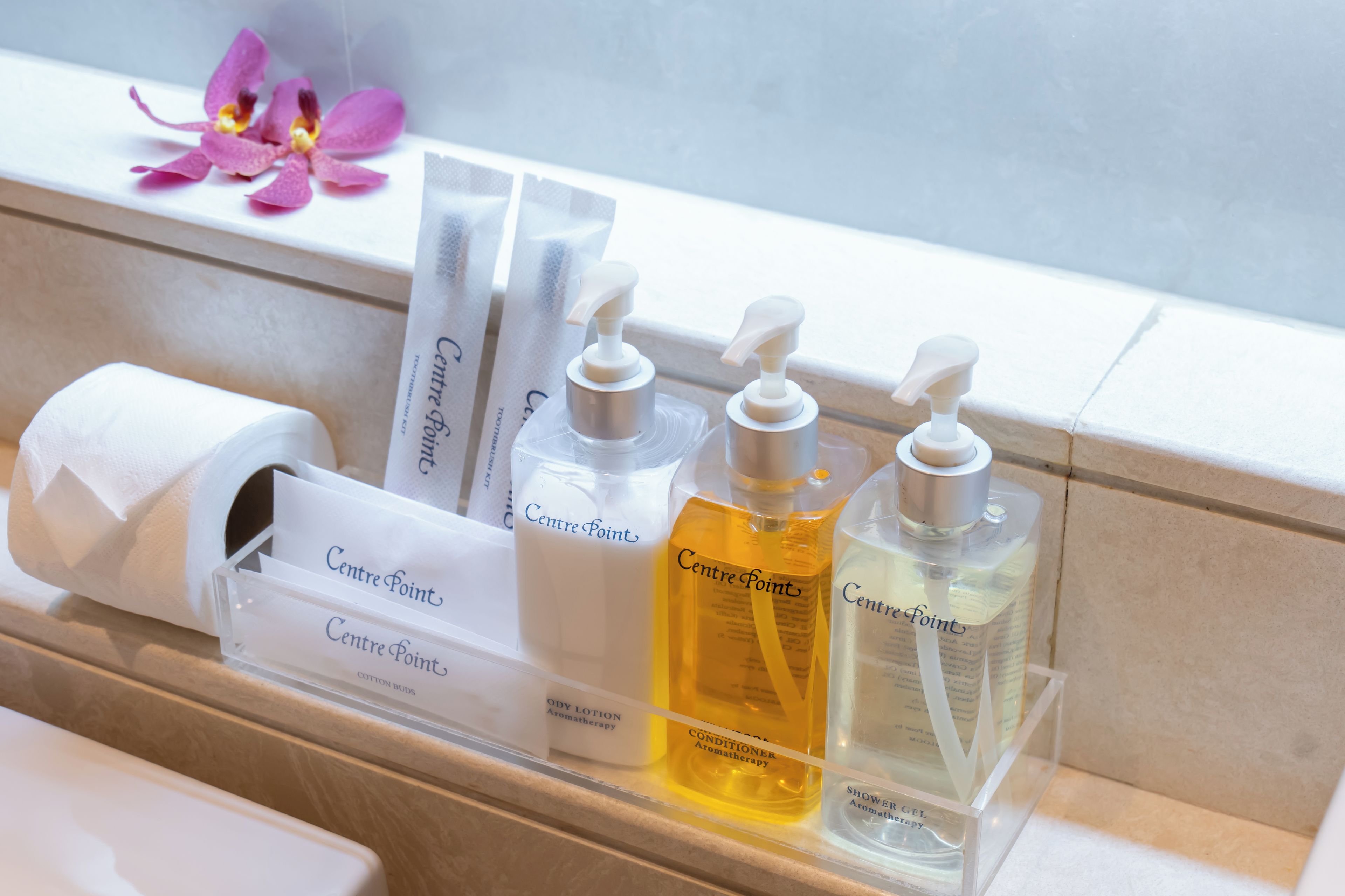 Estante de baño con artículos de aseo, incluyendo hisopos, loción corporal y gel de ducha.