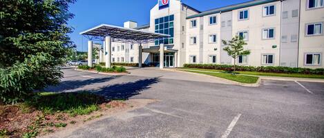 A modern hotel with a prominent '6' logo, a covered entrance, and a well-maintained parking area.