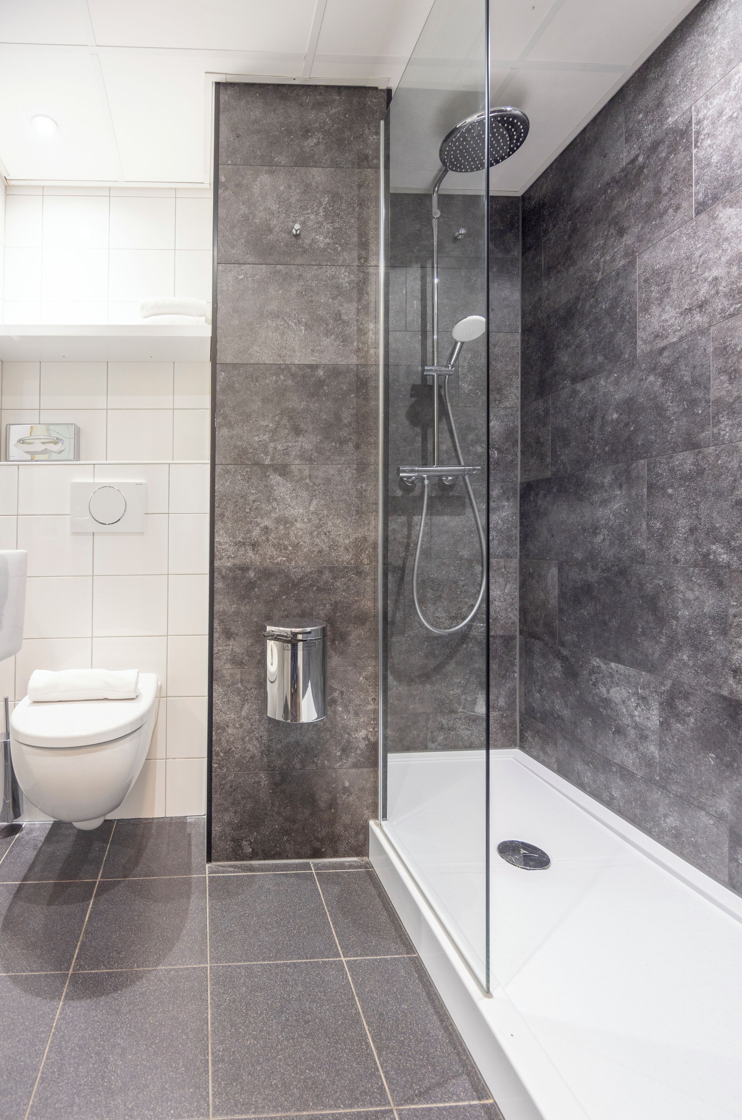 Ein modernes Badezimmer mit einer Duschkabine, einer Toilette und einem Waschbecken.