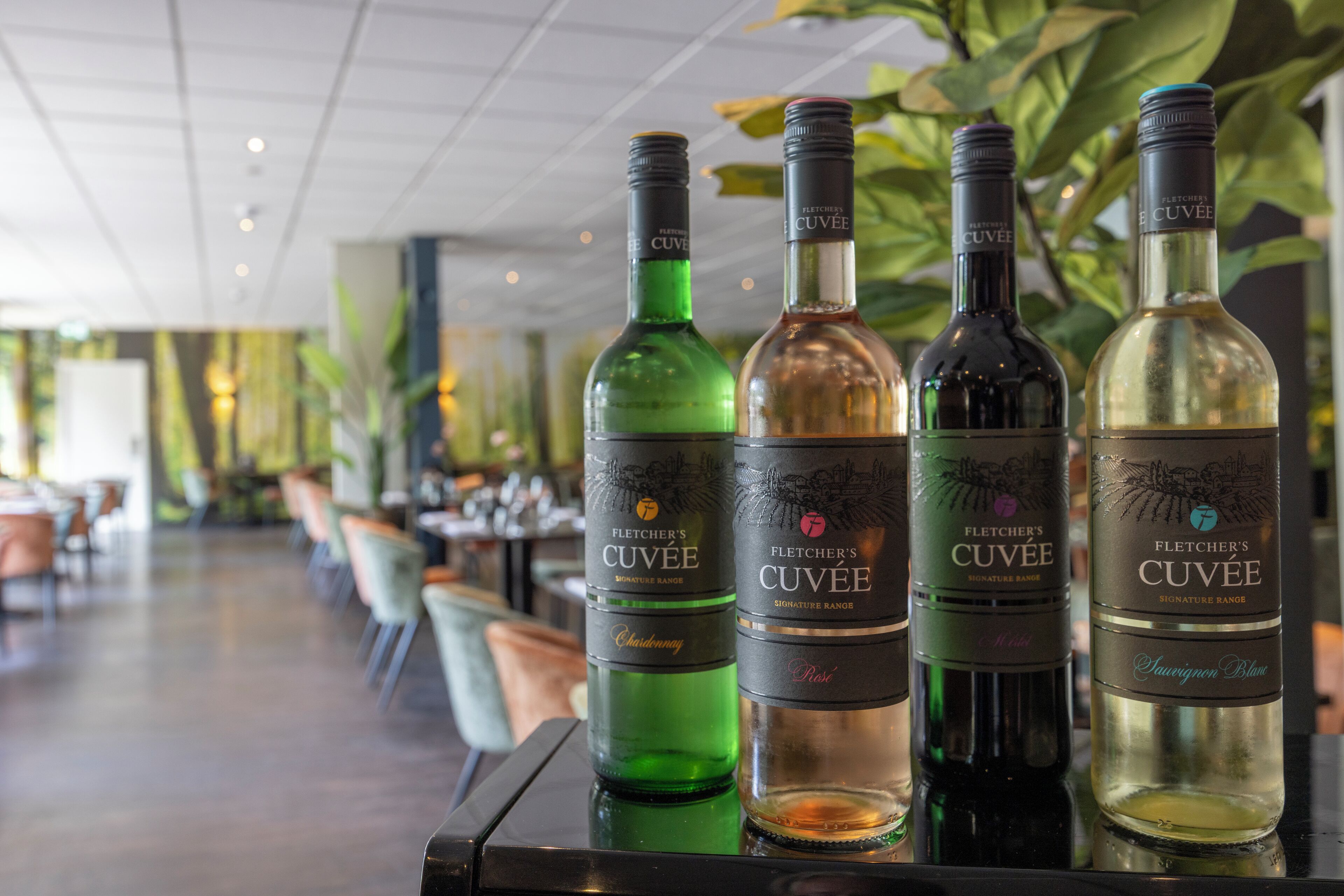 Una zona de bar con cuatro botellas de vino Fletcher's Cuvée.
