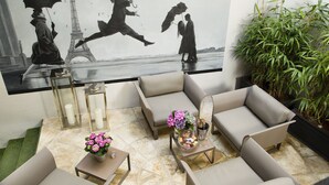 Een moderne lounge met een grote muurschildering, comfortabele zitplaatsen en een decoratieve plant.