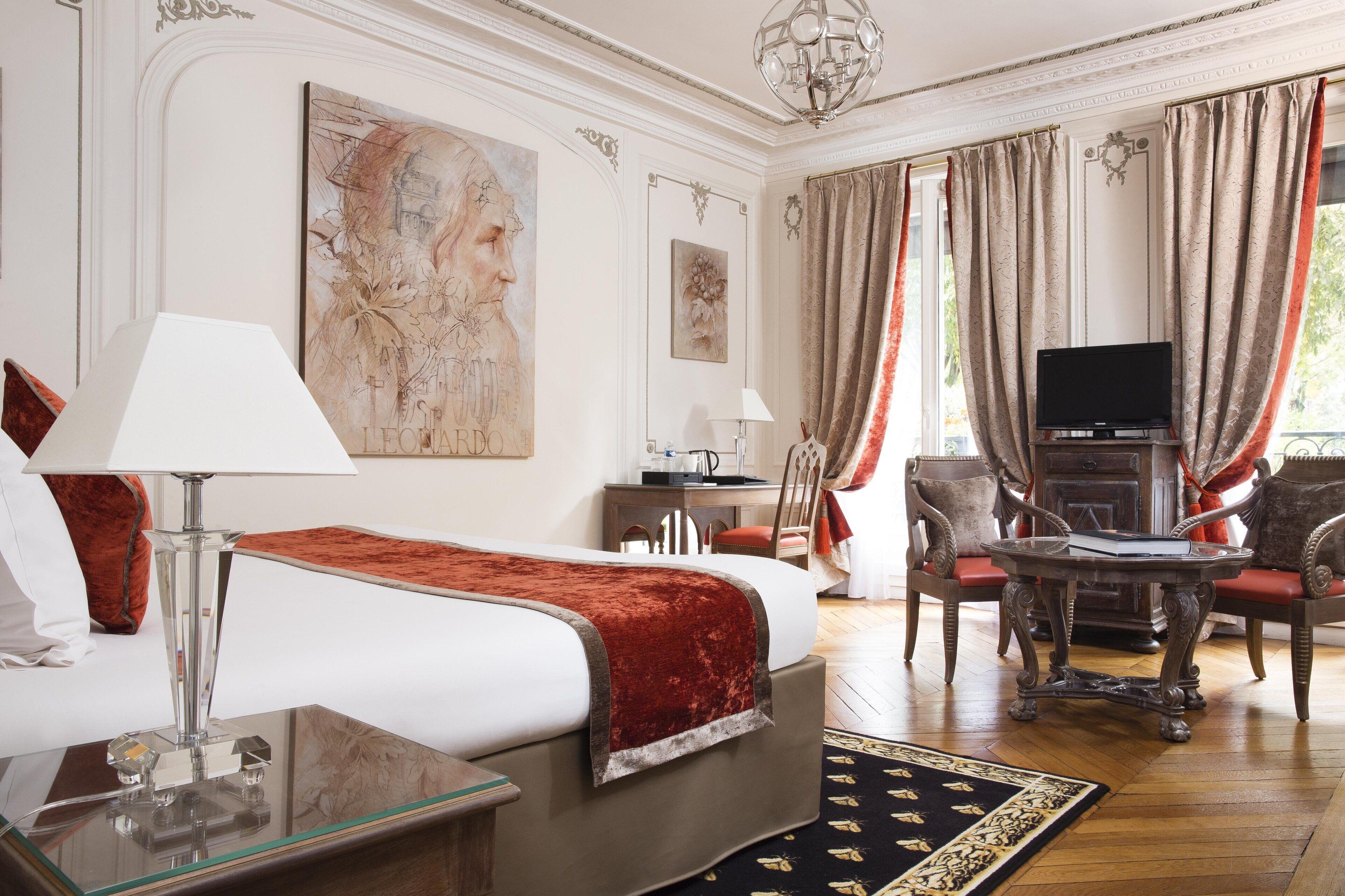 Une chambre d’hôtel équipée d’un lit, d’un bureau, d’une télévision et d’une chaise.