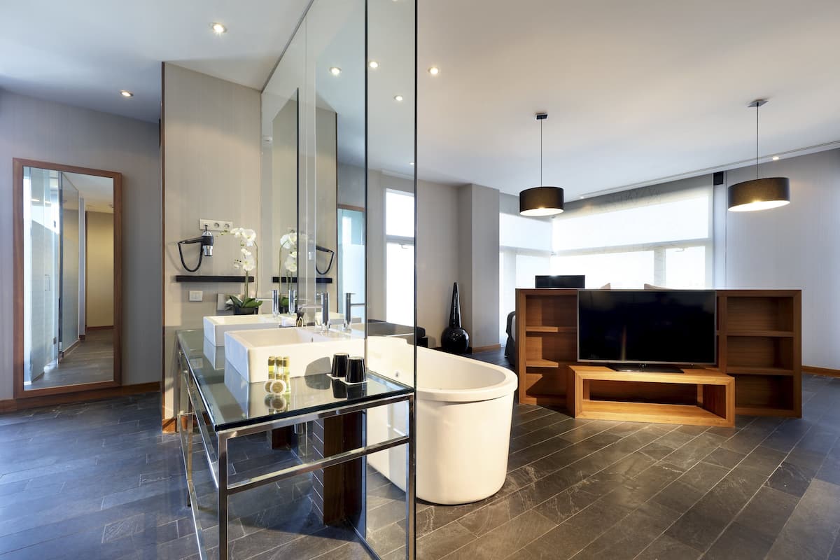 Ein modernes Badezimmer mit einer Glasdusche, einer weißen Badewanne und einem großen Spiegel.