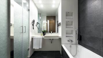 Un baño moderno con cabina de ducha de vidrio, lavabo blanco y bañera.