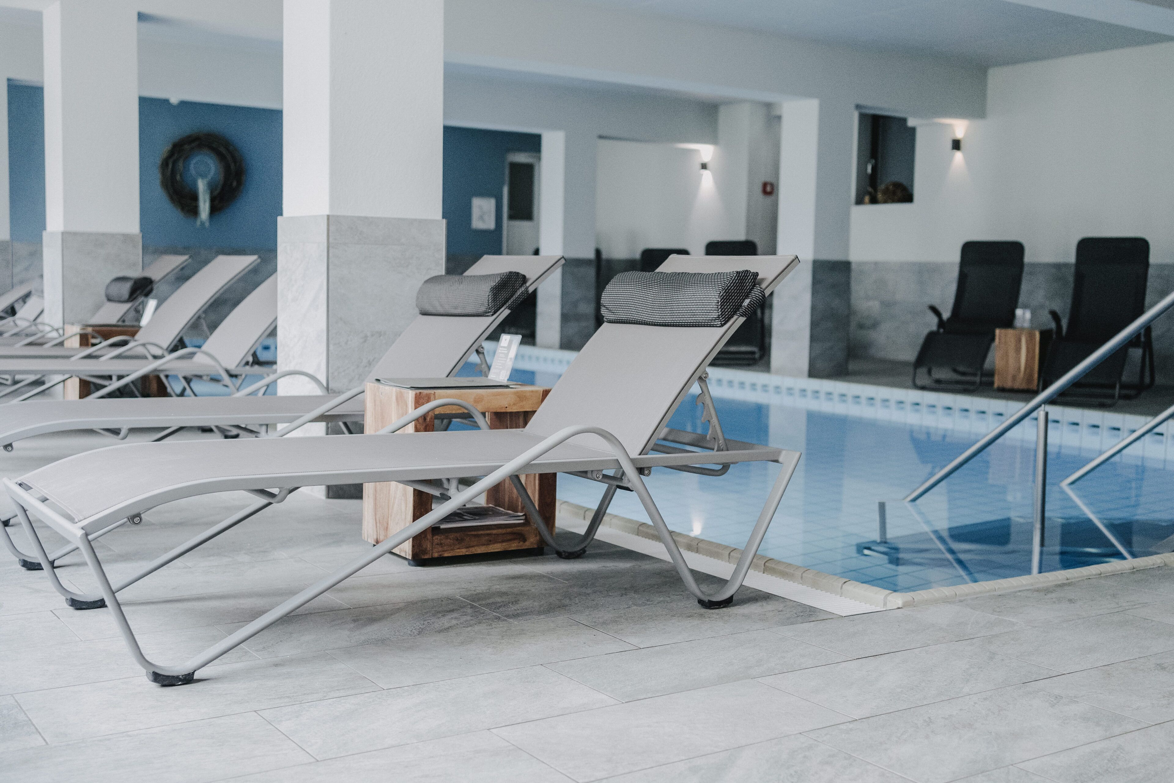 Ein Poolbereich mit Liegestühlen, einem Holztisch und freiem Blick auf den Pool.