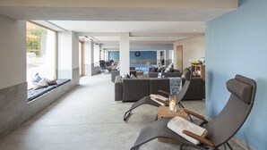 A spacious living area with a large window, a pool, and a modern interior design. - Landhotel Saarschleife (Mettlach)