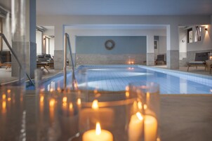 Una piscina techada, sillones reclinables de piscina