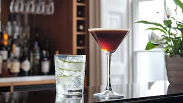 A bar setting with a martini glass and a highball glass.