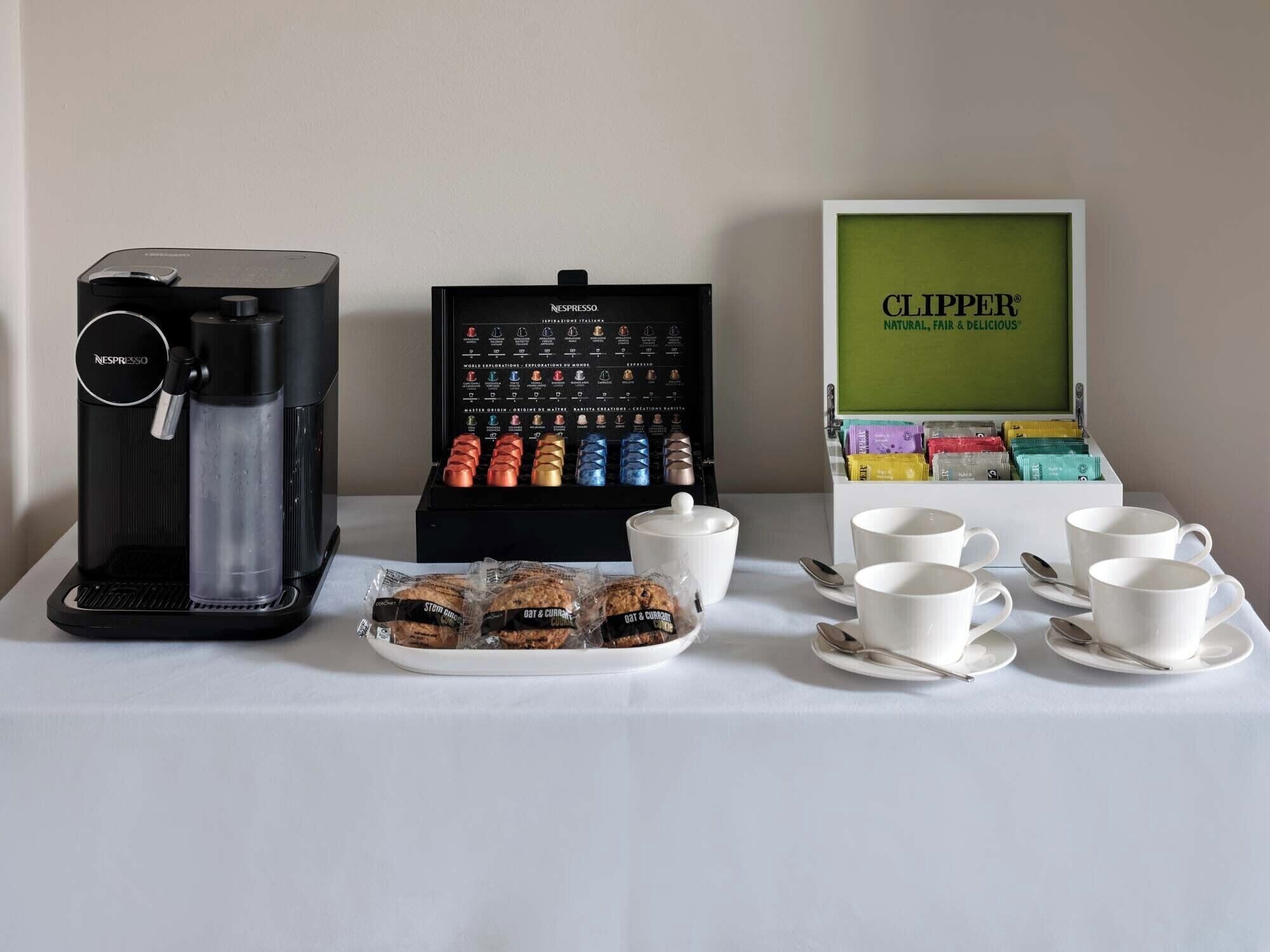 Uma máquina de café, exposição de cápsulas de café e um letreiro emoldurado com a palavra "CLIPPER".