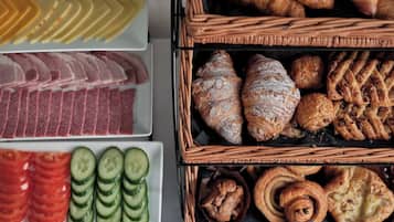 A variety of food items including sliced meats, vegetables, and pastries.