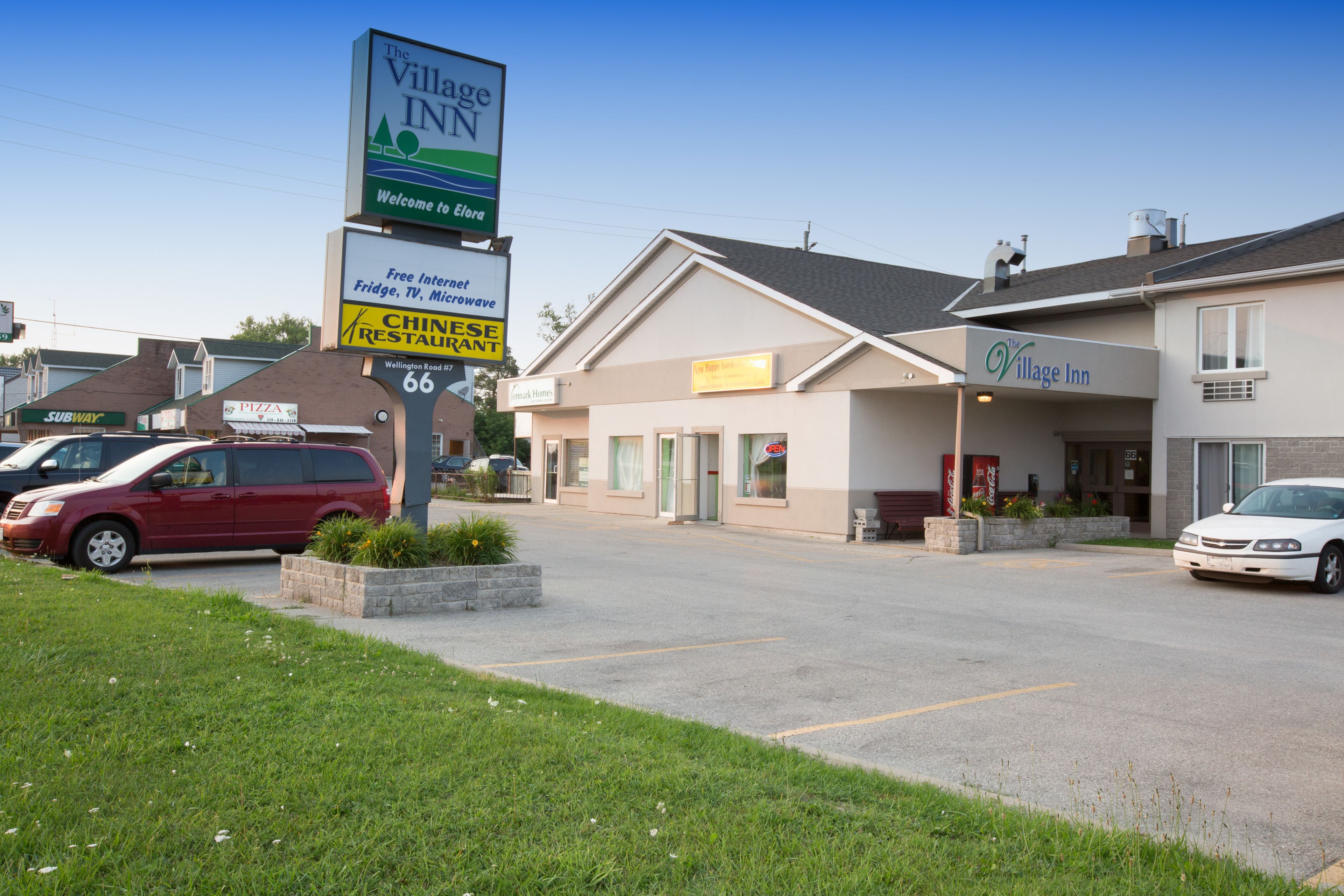 A Village Inn hotel with a parking lot, a Chinese restaurant sign, and a Subway sign.