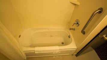Baño de hotel estándar con bañera, ducha y barandilla.